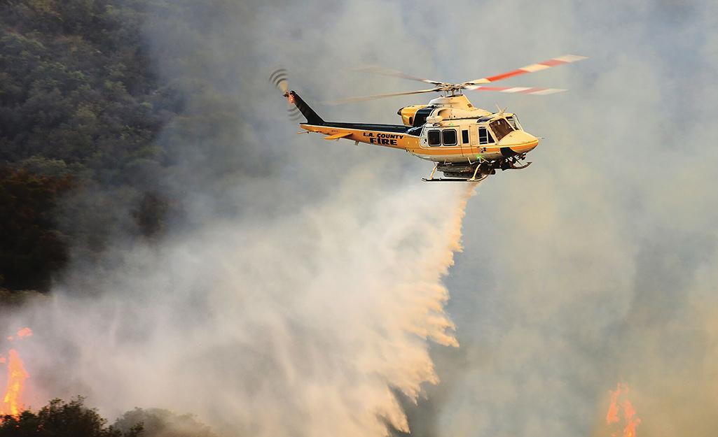 firefighting helicopter over forest fire
