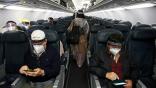 airline passengers in cabin wearing masks