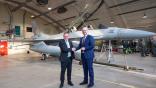 Defense Minister Bjørn Arild Gram congratulates Cristian Bădescu, Romania's ambassador to Norway, in front of one of three F-16s that were handed over at Rygge air station