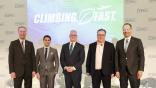 bizav executives posed for photo in from of EBACE 2024 and Climbing Fast logo screen
