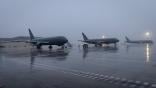 Three KC-46As on runway in fog