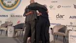 The panellists on the summit’s final panel have a group hug after a tempestuous session.