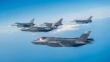 Lockheed Martin F-35s and F-16s flying in the sky