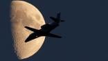 business jet inflight with the moon in the background