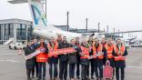 people standing in front of an Avanti Air aircraft at Berlin Brandenburg Airport