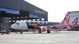 Airasia aircraft in front of a hangar