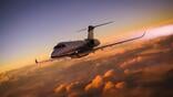 Business jet flying above clouds in the sunset