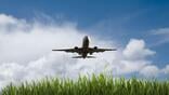 airplane flying over green grass