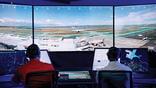 Two people at computers in air traffic control tower simulator