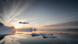 plane flying over water and ice