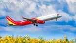 Vietjet aircraft flying above field of flowers