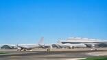 commercial aircraft sit on runway beside terminal