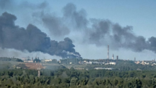 smoke billowing from oil refinery