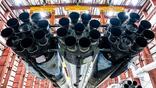 A SpaceX Falcon Heavy and its 27 Merlin engines are positioned in a hangar at Launch Complex 39A at the Kennedy Space Center in Florida, preparing to support the first National Reconnaissance Office mission using that launch vehicle. Credit: SpaceX