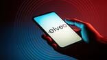 hand holding phone displaying elveo logo on screen