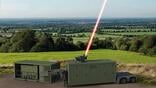 mobile command unit on rural field shooting laser beam skyward
