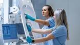 Two female FACC employees inspecting a component