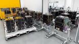 rows of satellite components on wheeled stands