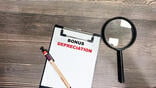 magnifying glass next to paper on clipboard that says BONUS DEPRECIATION