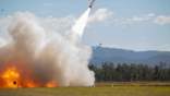 missile launches from grassy field