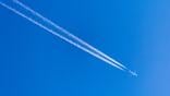 two lines of white contrails against blue sky