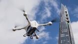 delivery drone in sky next to skyscraper
