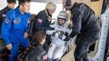 ESA astronaut sophie adenot helped out of spacecraft after splashdown