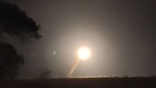 bright object streaks above dark horizon