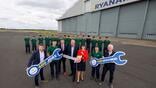 ryanair executives and staff pose outside an aircraft hangar