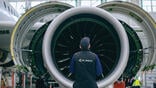 Air Astana employee standing in front of engine