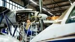 aircraft propeller engine inside a hangar is being fixed by an aircraft mechanic.
