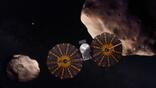 An illustration of the Lucy spacecraft flying by two of its asteroid targets. NASA/GSFC