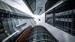 Tall buildings and an airliner overflying them