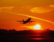 plane flying into sunset
