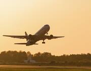 airplane flying into sunset