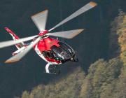 Leonardo NAW09 light helicopter flying above trees