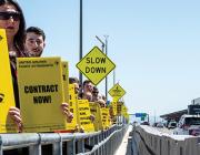 United Airlines flight attendants holding up yellow signs reading "pay us or chaos" and "contract now"