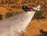 CH-47 Chinook dropping water over forested area