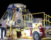 officials looking at the starliner capsule after it returned to earth