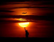 A plane flying past the Statue of Liberty