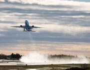 airplane taking off with exhaust behind