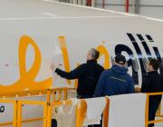 Employees applying graphics wrap to an aircraft 