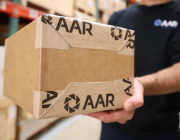 AAR employee holding a shipping box