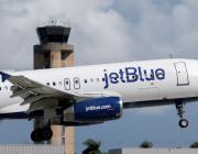 JetBlue aircraft flying near an air traffic control tower