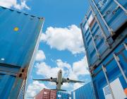 aircraft flying over shipping containers