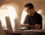 a man at a laptop using Wi-Fi on a Vista aircraft