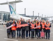 people standing in front of an Avanti Air aircraft at Berlin Brandenburg Airport
