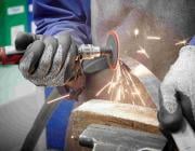 worker using an angle grinder on a disc