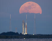 Space Launch System rocket and Orion spacecraft on launcher against rising Moon
