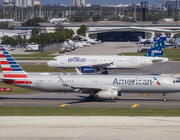 American Airlines and JetBlue Airlines aircraft taxiing on a runway at LAX.